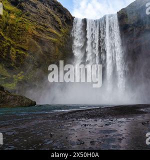 La cascata di Skogafoss che sfocia nel fiume Skogar, nel Katla Geopark, nell'Islanda meridionale, in Islanda Foto Stock