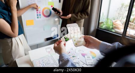 Brainstorming team di creativi graphic designer per il Web. I designer creativi presentano l'interfaccia utente ux al team. Riunione di lavoro del team di progettisti in ufficio Foto Stock