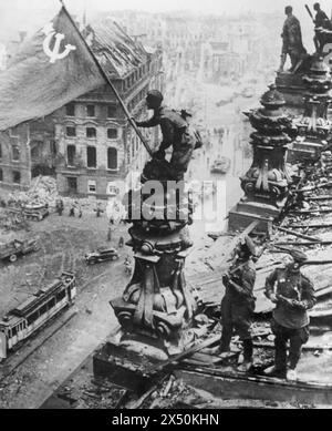 ESERCITO ROSSO I N BERLINO. Il soldato sovietico detiene la bandiera russa in cima al Reichstag nel maggio 1945. Foto: SIB Foto Stock