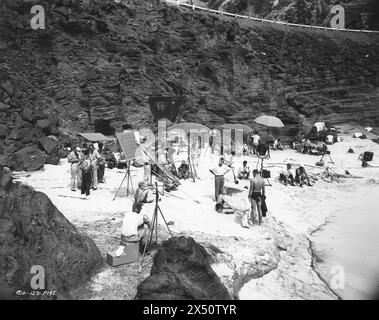 DEBORAH KERR e BURT LANCASTER con FRED ZINNEMANN con una grande troupe che filma la famosa scena della spiaggia in FROM HERE TO ETERNITY 1953 regista FRED ZINNEMANN romanzo JAMES JONES sceneggiatura DANIEL TARADASH Columbia Pictures Foto Stock