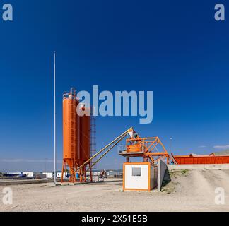 Fabbrica di cemento con silos, trasportatori e cielo blu Foto Stock