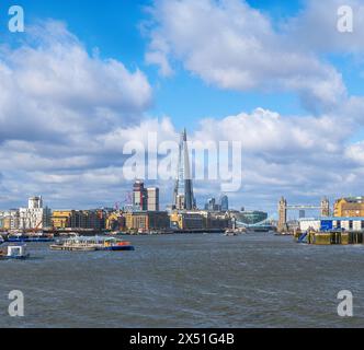 Vista del fiume Tamigi dalla passeggiata Rotherhithe con Tower Bridge e il grattacielo Shard all'orizzonte e traffico marittimo e traghetti in navigazione Foto Stock