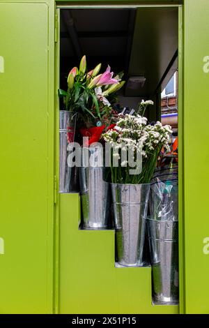 Vasi d'acciaio Galvenised con lillies in vendita a Soho, Londra Foto Stock