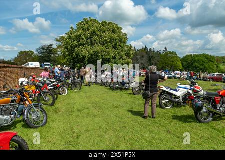 Earsham, Norfolk, Regno Unito – 5 maggio 2024. Appassionati di motociclette che guardano intorno alle motociclette in mostra in una piccola mostra di motociclette Foto Stock