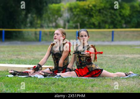 Due bambine di ginnastica artistica che si dividono con un tifoso, stadio. Apertura dell'Università di cultura fisica e sport. 20 giugno 2019. Kiev, Ukrai Foto Stock