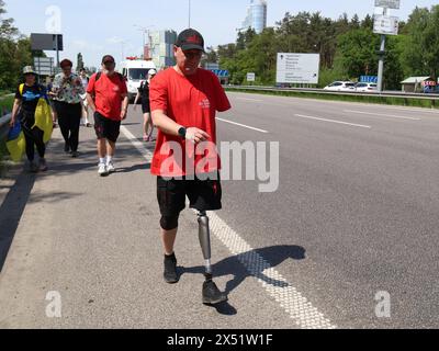 KIEV, UCRAINA - 6 MAGGIO 2024 - Serhii Khrapko (C), il veterano delle forze armate ucraine, la cui gamba sinistra e braccio sono stati amputati, partecipa a una maratona pedonale da Kiev a Boryspil per raccogliere fondi per la riabilitazione del suo compagno soldato Oleksandr Nadtochii, Kiev, capitale dell'Ucraina Foto Stock