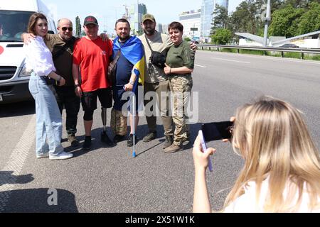 KIEV, UCRAINA - 6 MAGGIO 2024 - Serhii Khrapko (C), veterano delle forze armate ucraine, la cui gamba sinistra e braccio sono stati amputati, posa per una foto dopo una maratona a piedi da Kiev a Boryspil per raccogliere fondi per la riabilitazione del suo compagno soldato Oleksandr Nadtochii, Kiev, capitale dell'Ucraina Foto Stock