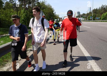 KIEV, UCRAINA - 6 MAGGIO 2024 - Serhii Khrapko (R), il veterano delle forze armate ucraine, la cui gamba sinistra e braccio sono stati amputati, partecipa a una maratona pedonale da Kiev a Boryspil per raccogliere fondi per la riabilitazione del suo compagno soldato Oleksandr Nadtochii, Kiev, capitale dell'Ucraina Foto Stock