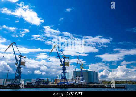 Wismar, Germania. 22 aprile 2024. Le gru per cantieri navali si trovano sul cantiere navale di fronte al salone di costruzione navale dell’ex cantiere navale MV. ThyssenKrupp Marine Systems (TKMS) ha acquisito il cantiere navale di Meclemburgo-Vorpommern dalla proprietà fallimentare del gruppo MV-Werften, che è fallita all’inizio del 2022. Crediti: Jens Büttner/dpa/Alamy Live News Foto Stock