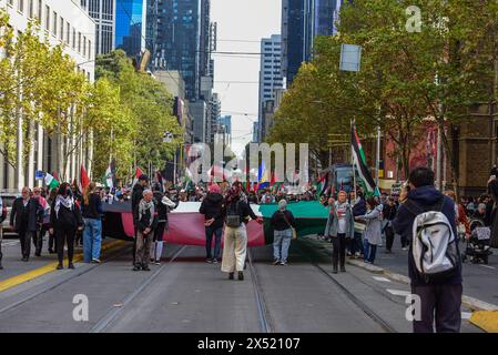 Melbourne, Australia. 5 maggio 2024. I manifestanti portano una gigantesca bandiera palestinese durante il raduno del giorno di maggio. I manifestanti pro-palestinesi si uniscono al raduno del giorno di maggio per marciare attraverso le strade del quartiere centrale degli affari di Melbourne verso la Victorian Trades Hall. La manifestazione politica è stata organizzata da Free Palestine Melbourne. Migliaia di persone marciarono contro la complicità del governo con il genocidio e si unirono ai sindacati, ai partiti comunisti, socialisti e anarchici per una manifestazione del giorno di maggio. Credito: SOPA Images Limited/Alamy Live News Foto Stock