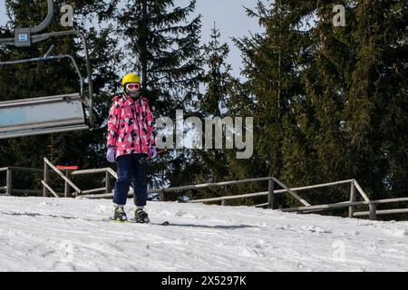 il giovane sciatore inizia a scendere da una pista da sci di medio livello. Attività ricreative attive. Stile di vita sano Foto Stock