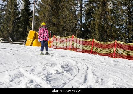 il giovane sciatore inizia a scendere da una pista da sci di medio livello. Attività ricreative attive. Stile di vita sano Foto Stock