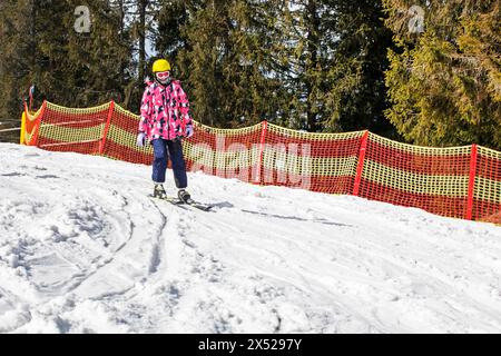 il giovane sciatore inizia a scendere da una pista da sci di medio livello. Attività ricreative attive. Stile di vita sano Foto Stock