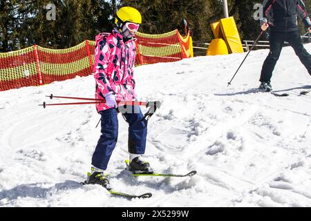 il giovane sciatore inizia a scendere da una pista da sci di medio livello. Attività ricreative attive. Stile di vita sano Foto Stock