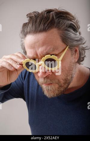 ritratto dell'uomo nordico con barba seria e occhiali da sole a forma di fiore Foto Stock