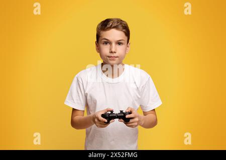 Ragazzo concentrato la riproduzione di video gioco con joystick Foto Stock