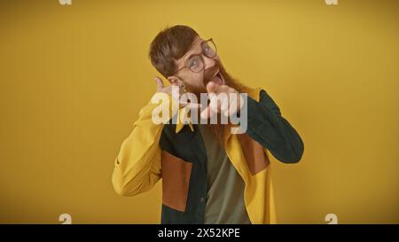 Giovane rossa barbuto che fa gesto chiamato me e punta alla telecamera isolata su sfondo giallo Foto Stock