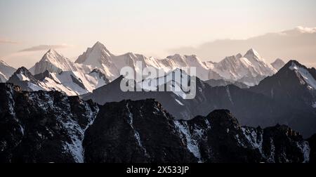 Alte vette montuose con ghiacciai al tramonto, passo Ala Kul, monti Tien Shan, Kirghizistan Foto Stock