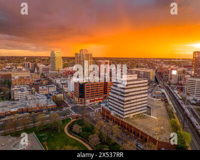 Vista aerea al tramonto del centro di New Brunswick nel New Jersey, con uffici e edifici residenziali e un colorato cielo arancione Foto Stock