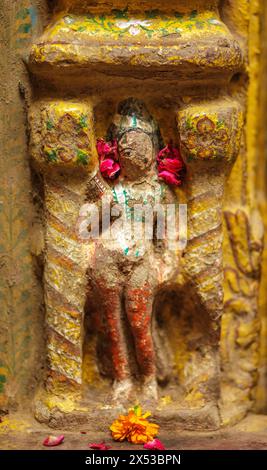 Statua in bassorilievo indossata dalle intemperie della dea a Varanasi, India. Foto Stock
