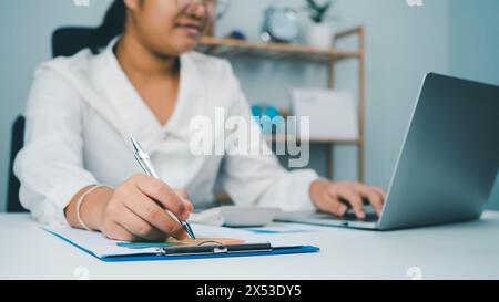 Le donne in affari utilizzano computer e documenti cartacei per analizzare le informazioni aziendali e gestirle. Analisi aziendale con grafici, indicatore Foto Stock