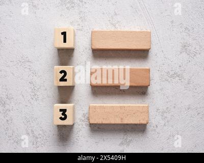 Elenco delle attività con numeri e blocchi di legno su sfondo bianco testurizzato. Concetto di pianificazione aziendale. Foto Stock