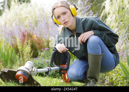 il giardiniere taglia l'erba con la macchina in piantagione Foto Stock