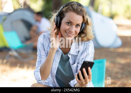 giovane donna che ascolta un lettore mp3 in una tenda Foto Stock
