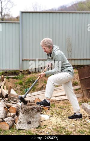 russo maturo 57 y.o. donna in tuta tritare legno Foto Stock