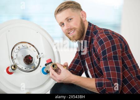 Plumber al lavoro di installare una pompa di circolazione Foto Stock