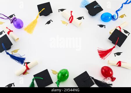 Concetto di cerimonia di laurea. Vista dall'alto di cappelli graduati, diplomi e palloncini colorati su bianco. Foto Stock