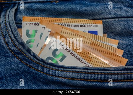 Tre banconote da 50 euro piegate incastrate nella tasca anteriore dei jeans blu 1 Foto Stock