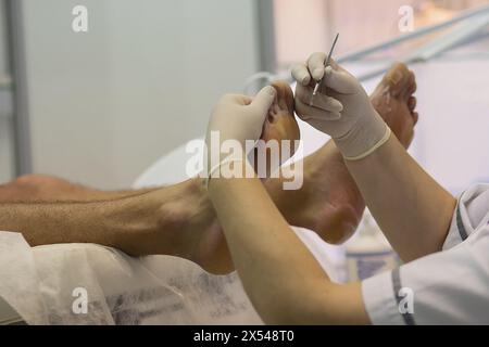 Estetista che fa pedicure hardware per il cliente maschile Foto Stock