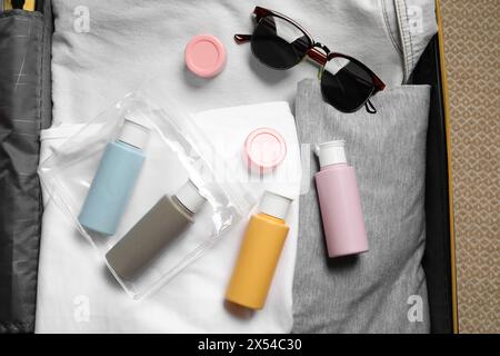 Kit cosmetico da viaggio, sacchetto di plastica e accessori in valigia, vista dall'alto Foto Stock