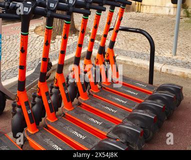 Fila di scooter elettrici Ride Movi di colore arancione a Faro, Algarve, Portogallo Foto Stock