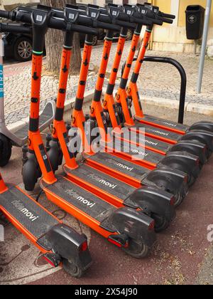 Fila di scooter elettrici Ride Movi di colore arancione a Faro, Algarve, Portogallo Foto Stock