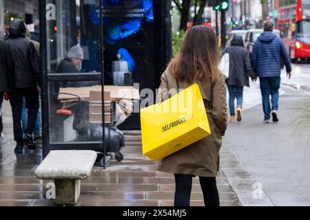 La pioggia del lunedì festivo non scoraggia i numerosi acquirenti e visitatori di Oxford Street che hanno sfidato il maltempo il 6 maggio 2024 a Londra, Regno Unito. Oxford Street è un importante centro commerciale nel West End della capitale ed è la strada commerciale più trafficata d'Europa, con circa mezzo milione di visitatori al giorno ai suoi circa 300 negozi, la maggior parte dei quali sono negozi di moda e di abbigliamento di alta moda. Foto Stock