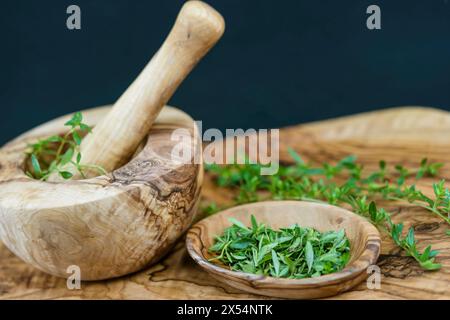 Salato estivo, calamint (Satureja hortensis), schiacciato in una ciotola di legno e in un mortaio Foto Stock