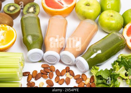 Diversi frullati di frutta e verdura in bottiglie di vetro su sfondo bianco Foto Stock
