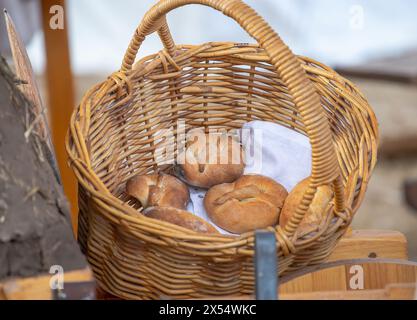 i panini appena sfornati si trovano in un cestino di vimini, pane fresco, natura morta. Foto di alta qualità Foto Stock