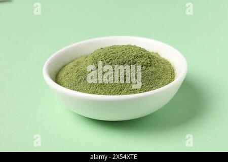 Erba di frumento in polvere nella ciotola sulla tavola verde Foto Stock