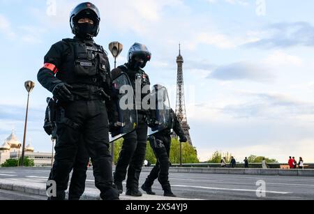 6 maggio 2024, Francia, Parigi: Gli agenti di polizia motociclistica camminano vicino alla Torre Eiffel durante la visita di stato del Presidente della Cina. Le Olimpiadi e le Paralimpiadi si svolgono in Francia in estate. Foto: Robert Michael/dpa Foto Stock