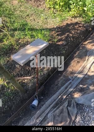 Impostazione di restrizioni di bordo acquistare mettendo cordolo di confine pietre in massa di calcestruzzo umido Foto Stock