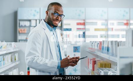 Farmacia: Ritratto del farmacista nero professionista utilizza il computer tablet digitale, controlla l'inventario della medicina, guarda la fotocamera e sorride in modo affascinante. Farmacia negozio con prodotti sanitari Foto Stock
