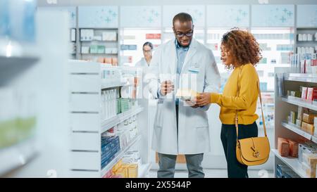 Farmacia: Farmacista professionista nero che aiuta bella cliente latino femminile con raccomandazione, consigli, parlare di medicina. Farmacia con pieno di farmaci, pillole, assistenza sanitaria, pacchetti di prodotti di bellezza Foto Stock