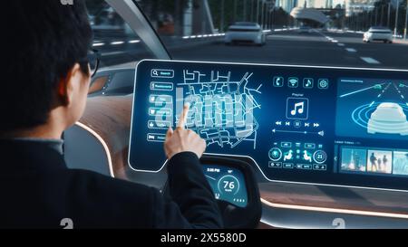 Concetto futuristico: Posizione elegante per un uomo d'affari su un'app di navigazione interattiva su un cruscotto di realtà aumentata mentre è seduto in un'auto elettrica autonoma a emissioni zero. Foto Stock