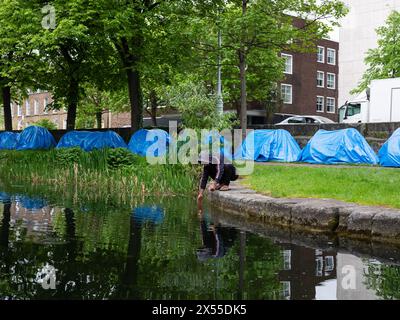 Un richiedente asilo si lava nel Canal grande nella città di Dublino, in Irlanda, dove è stato istituito un campo improvvisato vicino all'Ufficio internazionale di protezione di Mount Street. Foto Stock