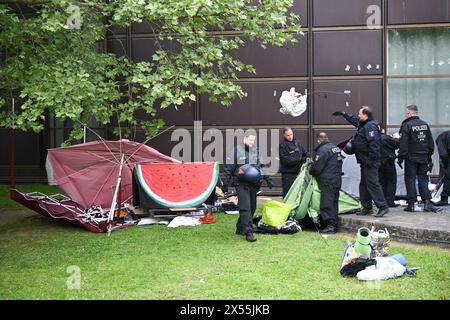 Berlino, Germania. 7 maggio 2024. Gli agenti di polizia ripuliscono il campo dopo lo sfratto di una manifestazione filo-palestinese da parte del gruppo "coalizione studentesca Berlino" nel cortile del teatro di Freie Universität Berlin. Gli attivisti pro-palestinesi hanno occupato un cortile della libera Università di Berlino martedì. Crediti: Sebastian Christoph Gollnow/dpa/Alamy Live News Foto Stock