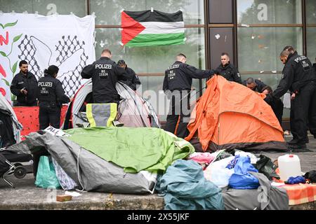 Berlino, Germania. 7 maggio 2024. Gli agenti di polizia ripuliscono il campo dopo lo sfratto di una manifestazione filo-palestinese da parte del gruppo "coalizione studentesca Berlino" nel cortile del teatro di Freie Universität Berlin. Gli attivisti pro-palestinesi hanno occupato un cortile della libera Università di Berlino martedì. Crediti: Sebastian Christoph Gollnow/dpa/Alamy Live News Foto Stock