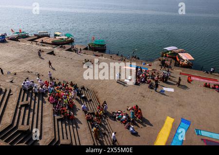 i pellegrini allineano i gradini dei ghati di maheshwar mentre i sacerdoti conducono le preghiere quotidiane e i rituali mattutini Foto Stock